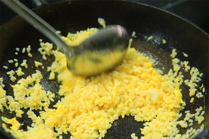 大火加熱炒鍋，再入油，燒到四至五成熱時倒入雞蛋液，在未凝結(jié)之前，加米飯煸炒，不停翻炒并用鍋鏟將成塊的米飯碾開、撥散。