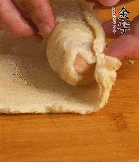 吐司卷起香腸，吐司尾端涂抹少許全蛋液，卷好的吐司表面蘸上蛋液，在裹上一層面包糠，送入預(yù)熱好的烤箱中。