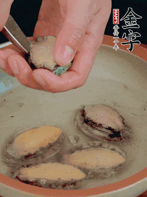 鮑魚加鹽、清水浸泡，用勺子挖出鮑魚肉。