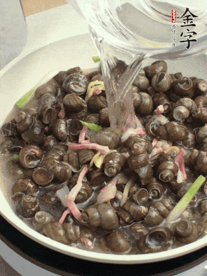 倒處理干凈的螺螄翻炒，加3勺料酒。加清水蓋過(guò)螺螄，中火蓋蓋煮5分鐘。