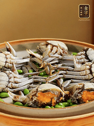 盤(pán)底鋪毛豆，依次放大閘蟹、咸肉， 淋一圈料酒、豉油。